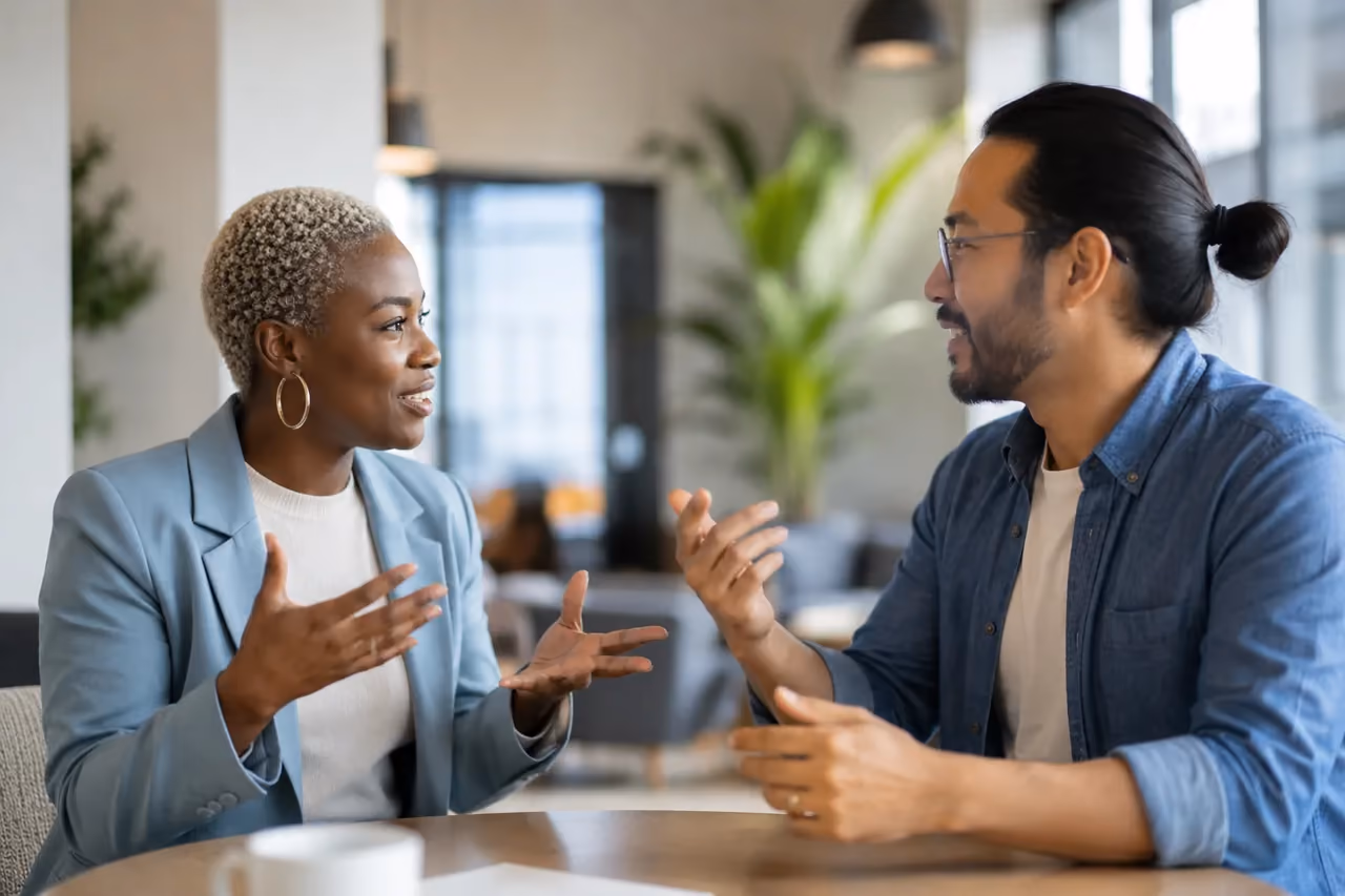 Two colleagues in a lively conversation at a table